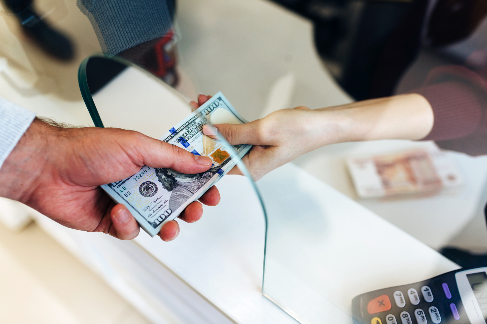 El hombre cambia el dinero en un cambio de divisas