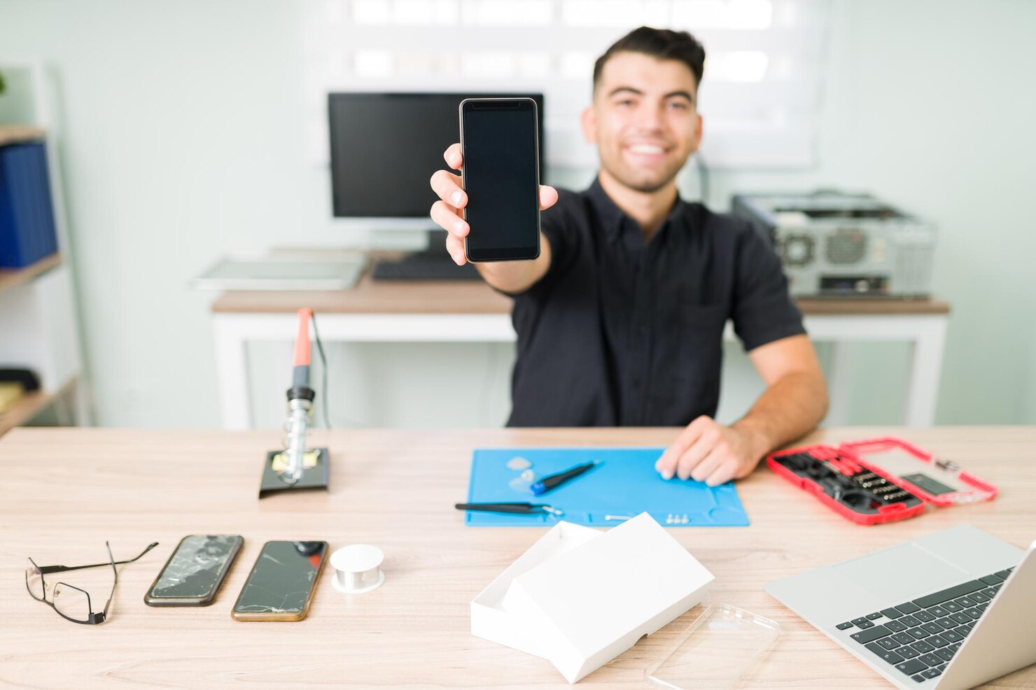 como-nuevo-joven-feliz-mostrando-telefono-inteligente-fijo-tecnico-sonriente-reparando-pantalla-rota-smartphone